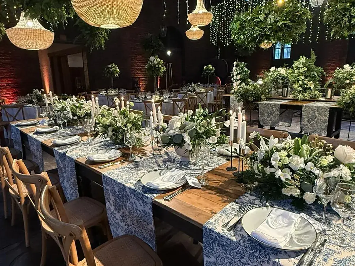 Detalle de mesa montada con velas, flores blancas y camino de mesa estampado